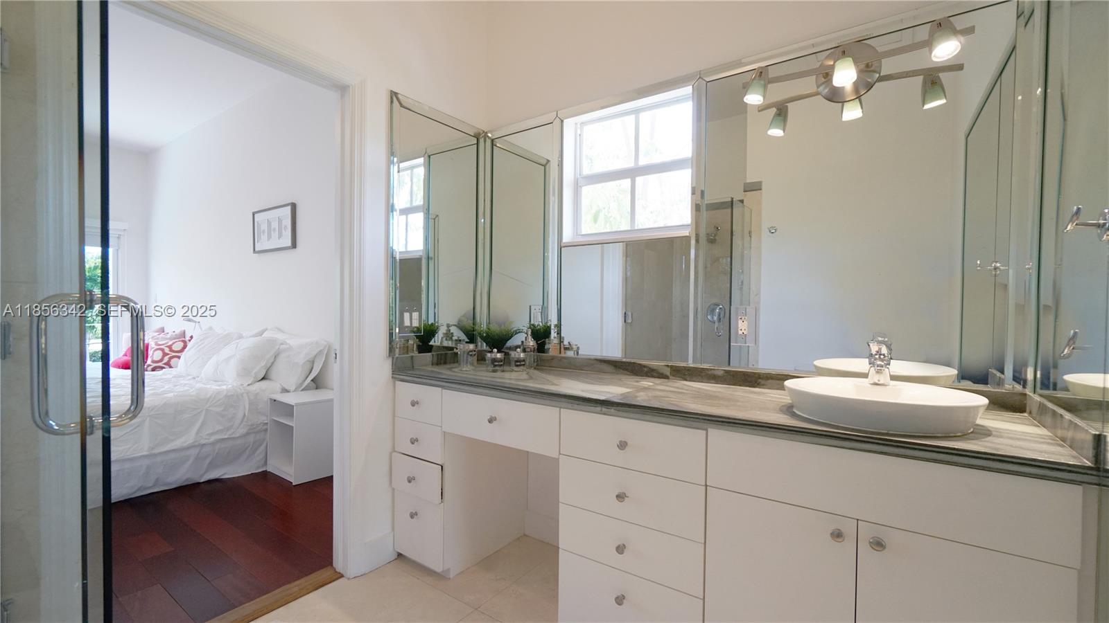 691 Ridgewood Road Key Biscayne, FL 33149 - Photo 49 of 67 a en suite bathroom with double sink and a mirror