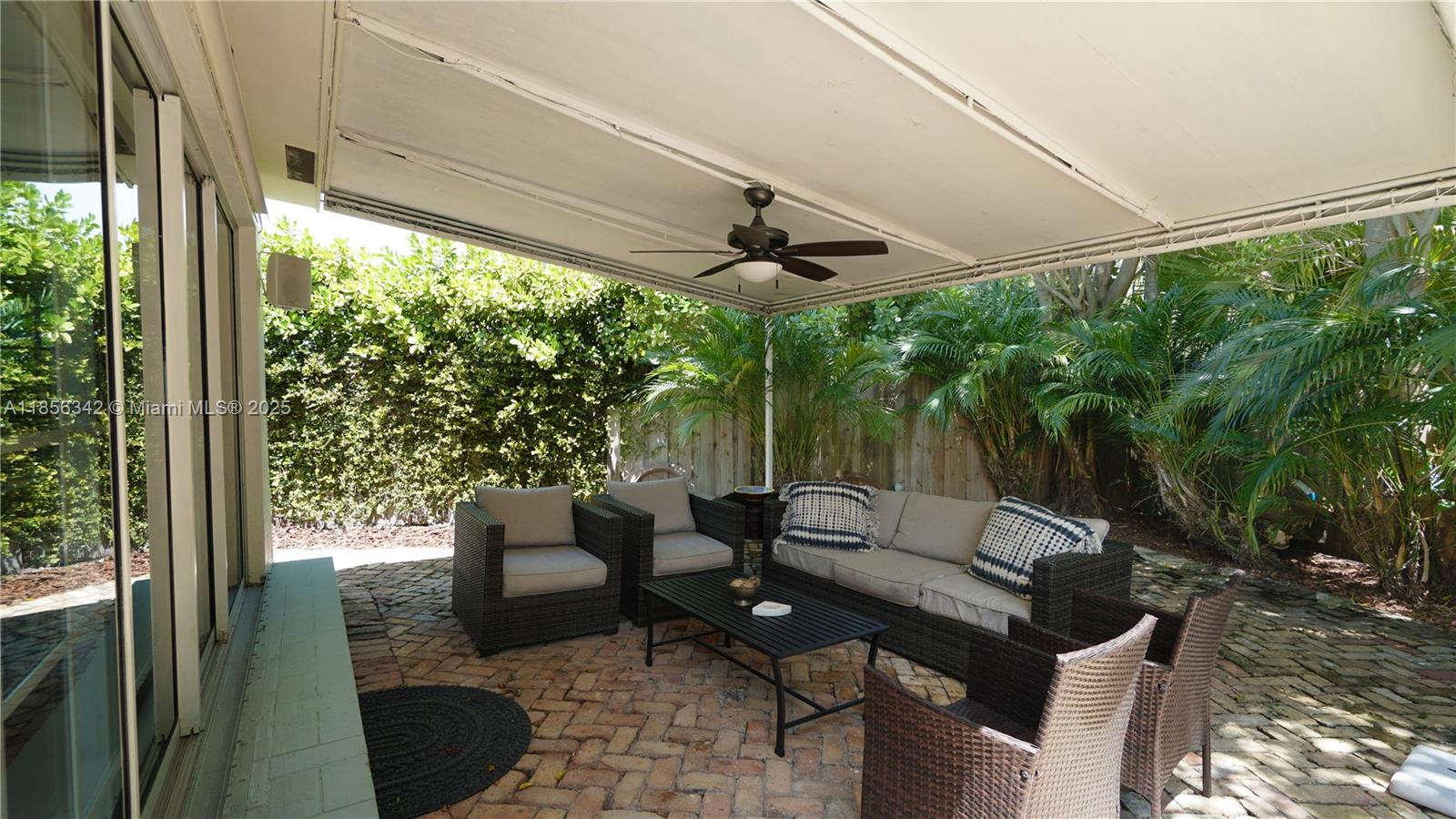 691 Ridgewood Road Key Biscayne, FL 33149 - Photo 58 of 67 a view of a patio with a table chairs and a backyard