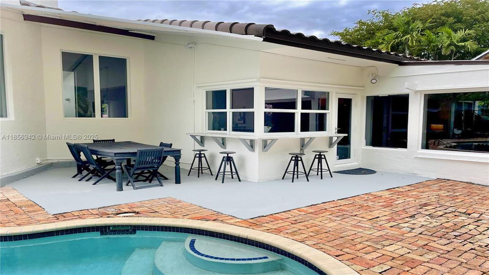 691 Ridgewood Road Key Biscayne, FL 33149 - Photo 67 of 67 a view of a patio with table and chairs