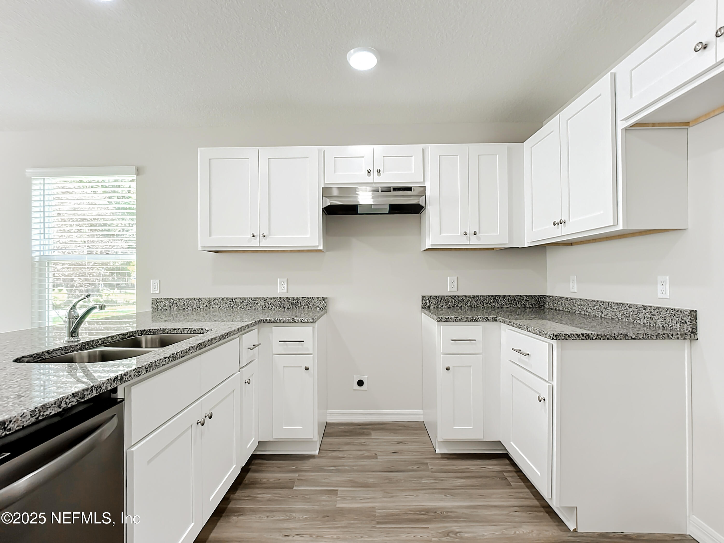 5669 George Court, Unit 101 Jacksonville, FL 32277 - Photo 5 of 10 a kitchen with granite countertop a sink stove and cabinets