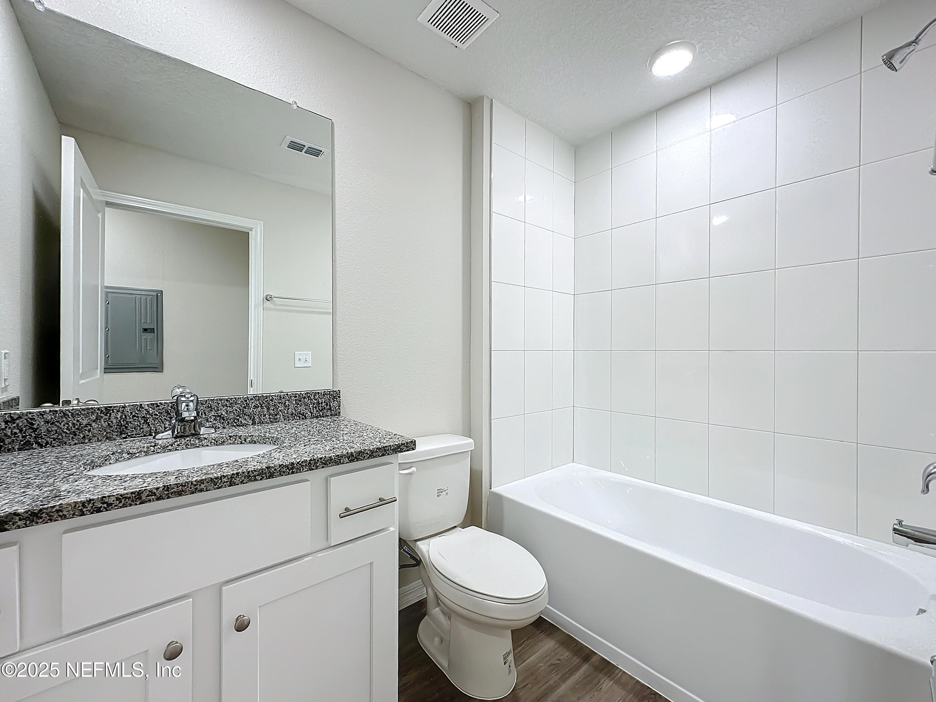 5669 George Court, Unit 101 Jacksonville, FL 32277 - Photo 9 of 10 a bathroom with a granite countertop toilet sink and mirror