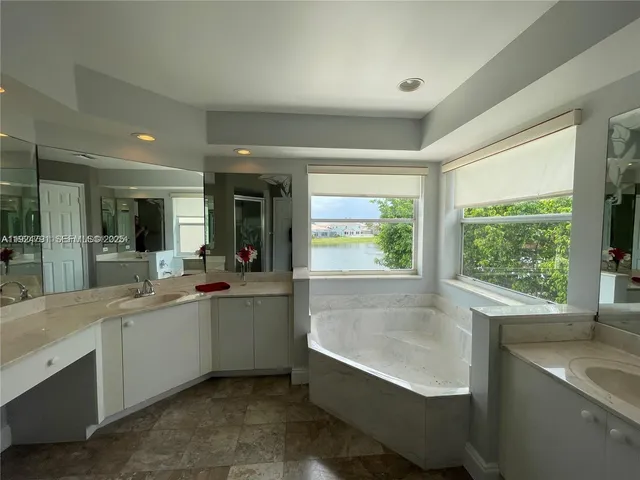 an empty room with wooden floor and fan