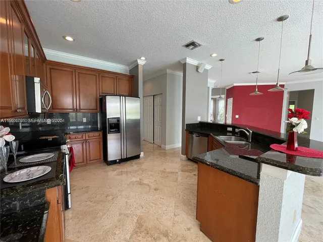 a kitchen with granite countertop stainless steel appliances a stove sink and microwave
