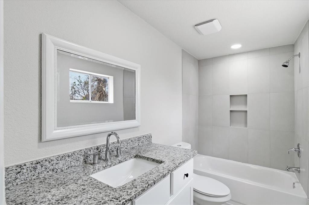 404 South Murray Street McKinney, TX 75069 - Photo 9 of 23 a bathroom with a granite countertop sink toilet and shower