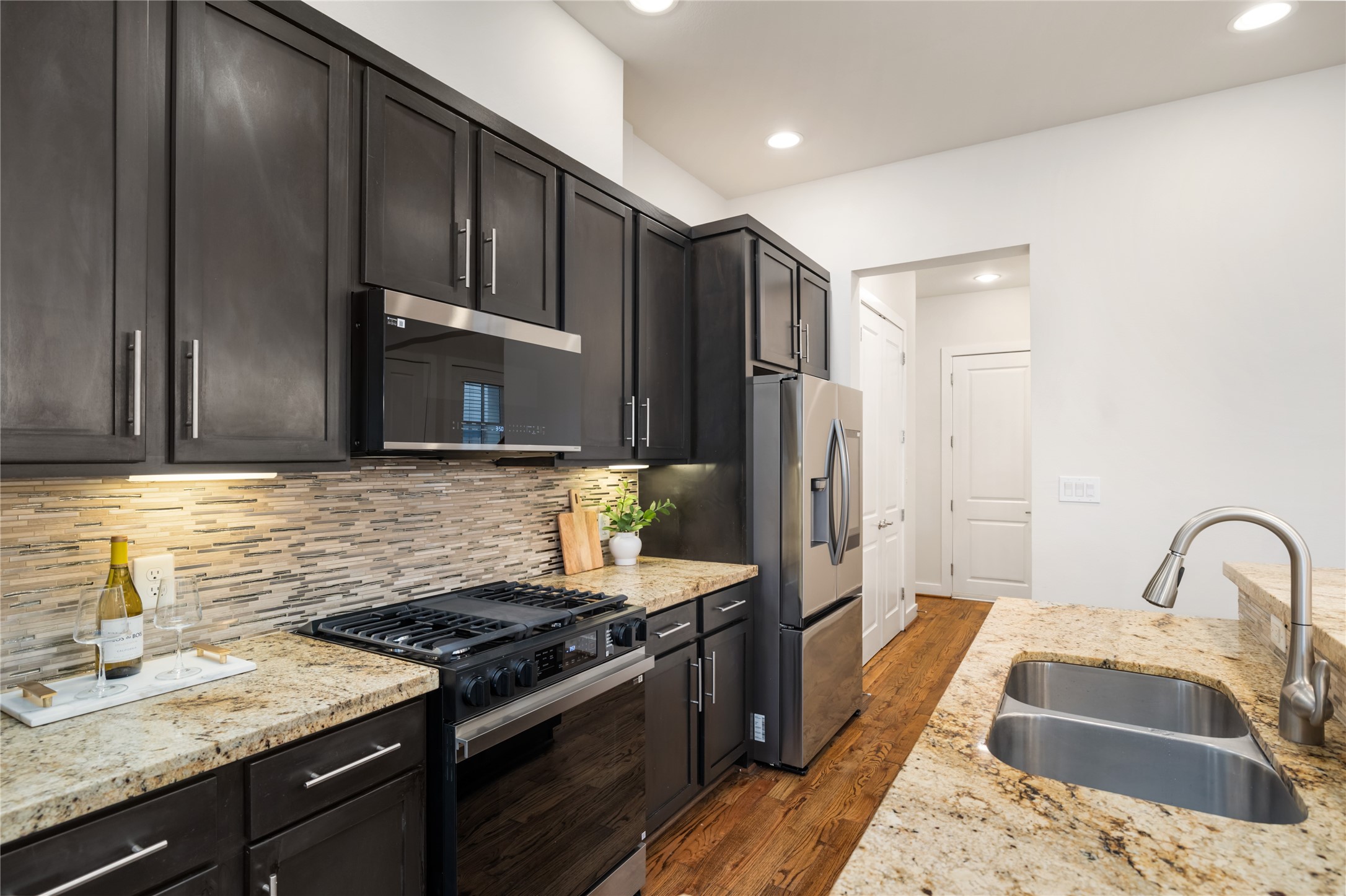 4409 Schuler Street, Unit A Houston, TX 77007 - Photo 12 of 30 a kitchen with granite countertop stainless steel appliances and wooden cabinets