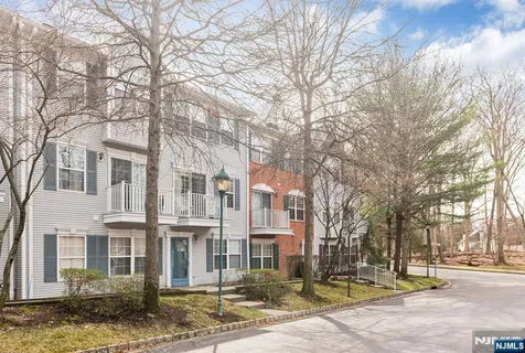 a front view of a building with lot of trees