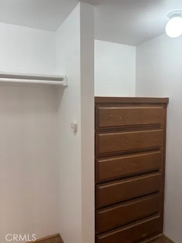 a view of walk in closet with empty racks