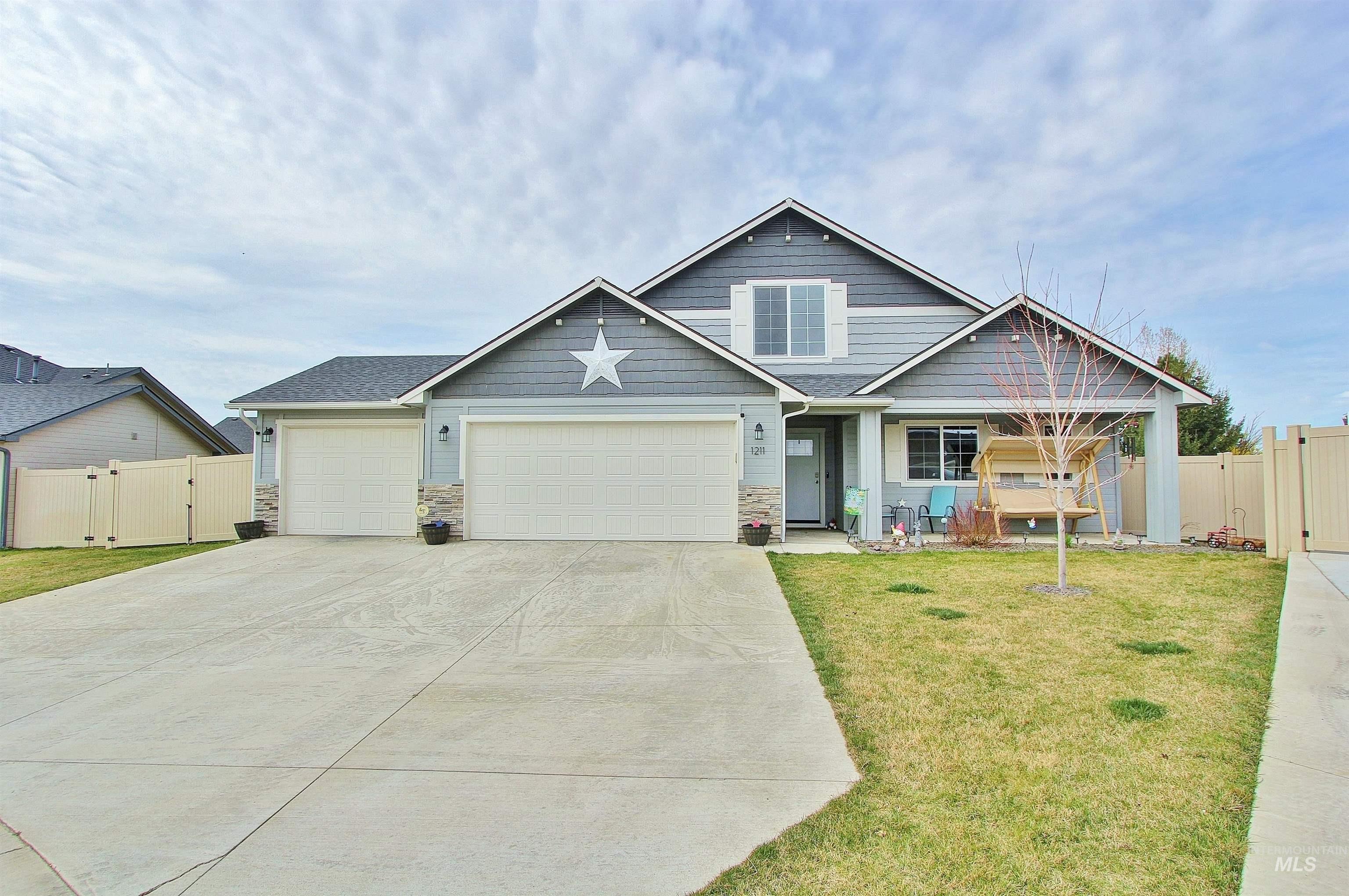 1211 Mahogany Street Parma, ID 83660 - Photo 1 of 22 Craftsman-style house with a gate, an attached garage, stone siding, and concrete driveway