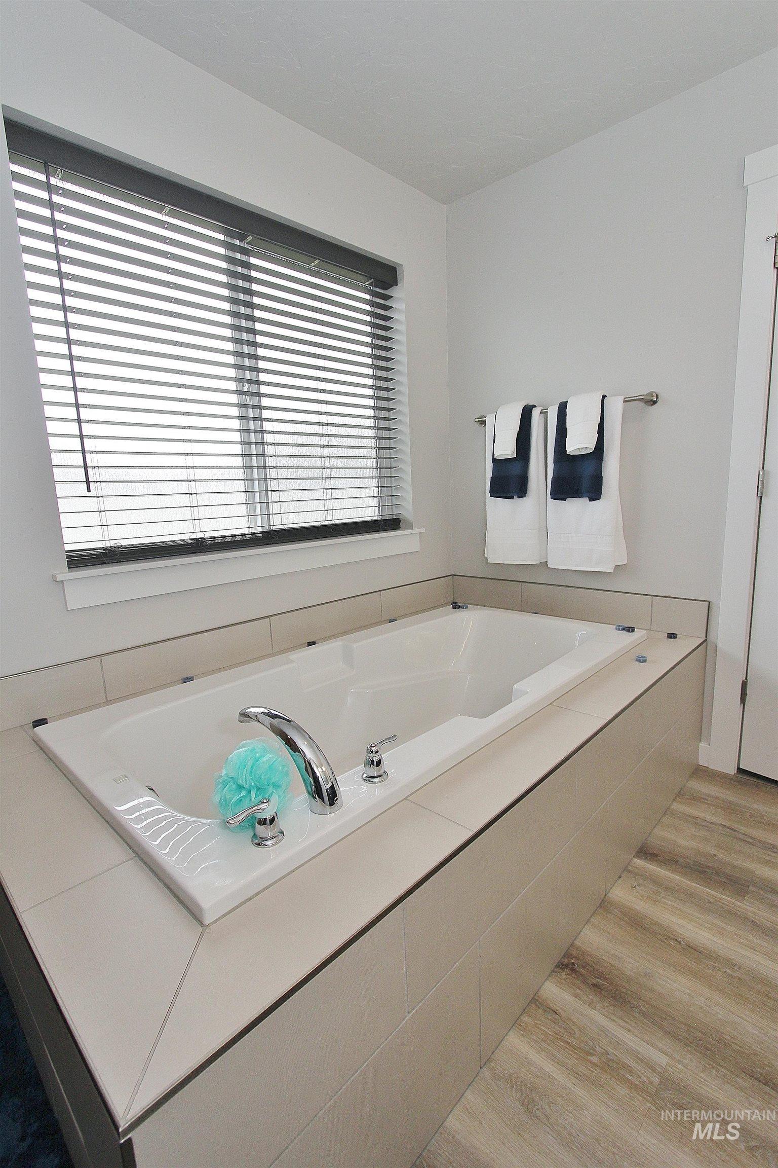 1211 Mahogany Street Parma, ID 83660 - Photo 12 of 22 Bathroom with a garden tub and light wood-style flooring