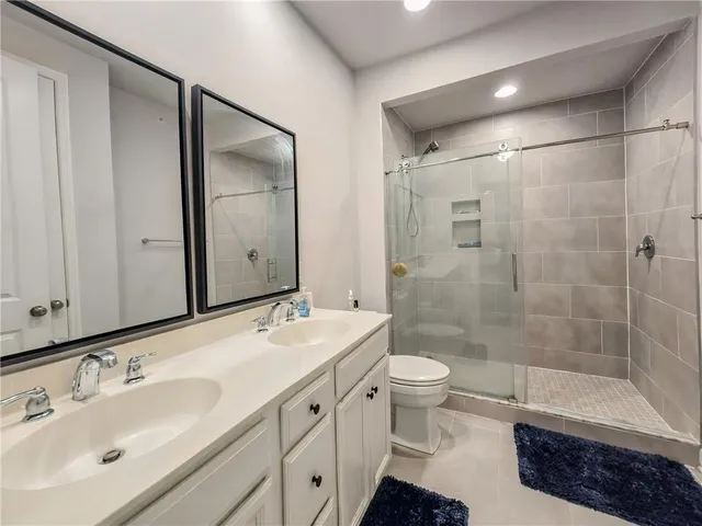 a bathroom with a double vanity sink toilet and shower