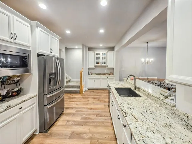 a kitchen with stainless steel appliances granite countertop a refrigerator and a sink