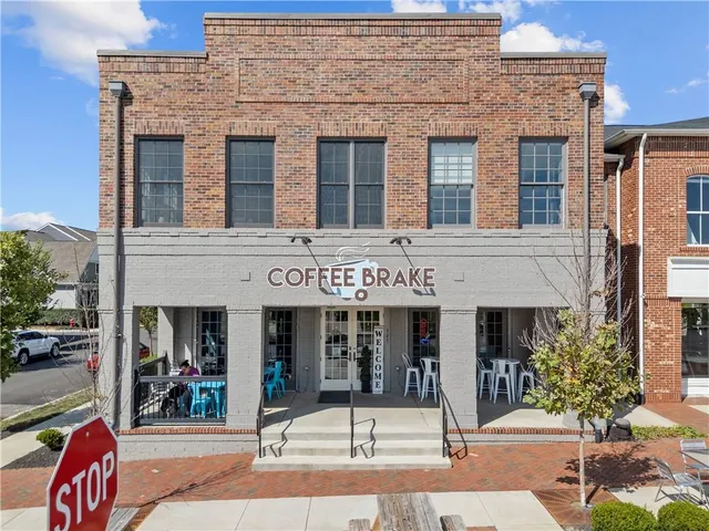 a front view of a brick building with large windows