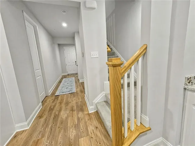 a view of a hallway with wooden floor and staircase