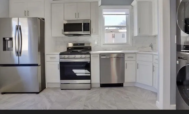 a kitchen with stainless steel appliances a refrigerator stove and microwave