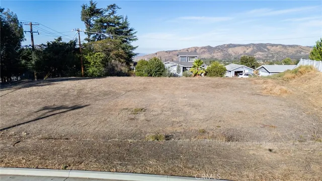 a view of a dry yard with mountains in the background