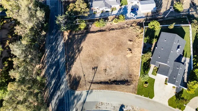 an aerial view of a house with a yard wooden table and chairs