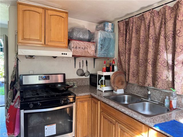 a kitchen with stainless steel appliances granite countertop a sink stove and cabinets