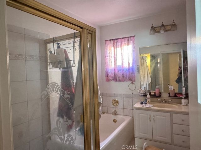 a bathroom with a bathtub sink vanity and mirror