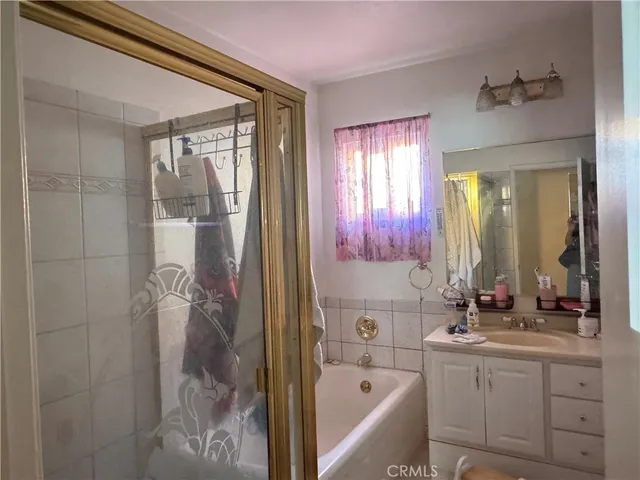 a bathroom with a bathtub sink vanity and mirror