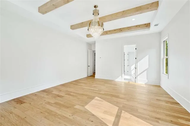 a view of empty room with wooden floor and ceiling fan