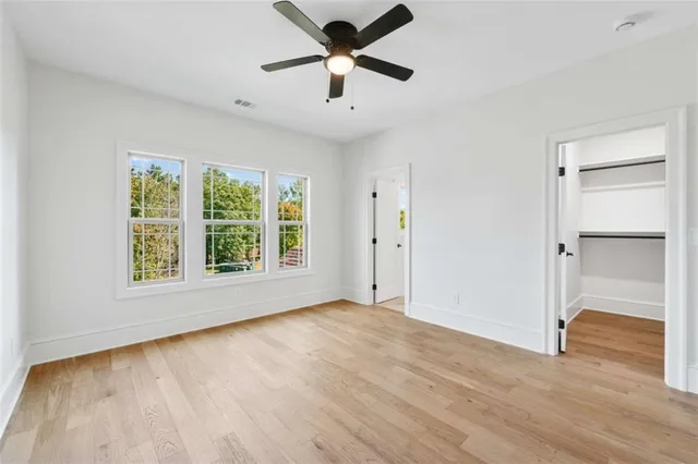 an empty room with a window and a ceiling fan
