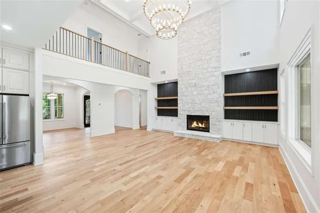 a view of an empty room with kitchen and a window