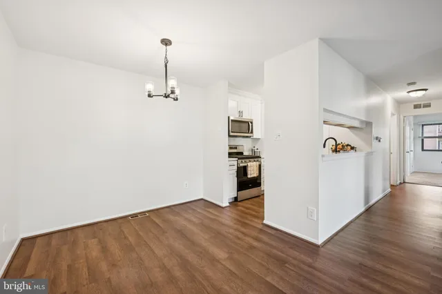 a view of a hallway with wooden floor and workspace