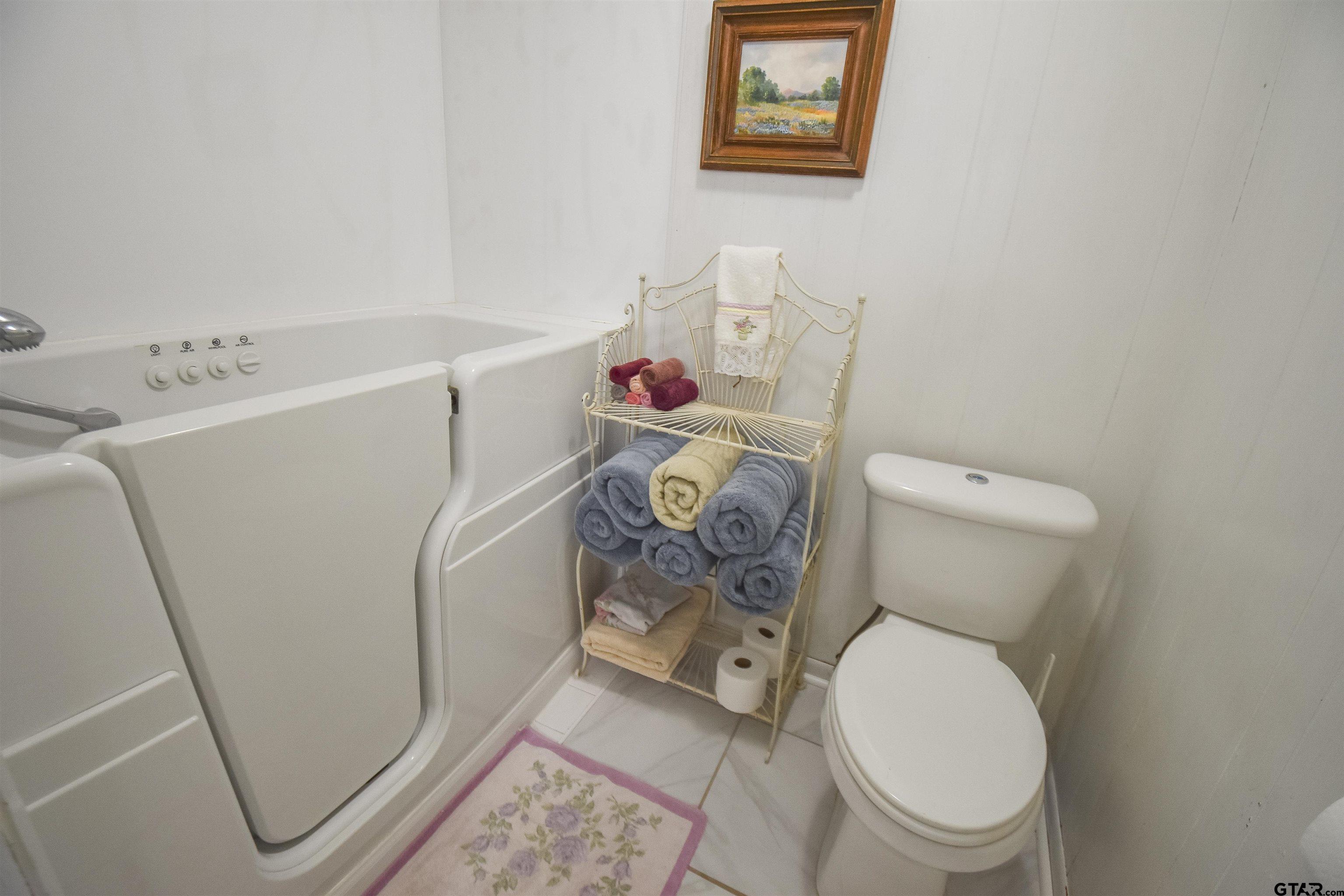 355 West Sugar Hill Road Reklaw, TX 75784 - Photo 21 of 38 a white toilet sitting next to a white sink and cabinets
