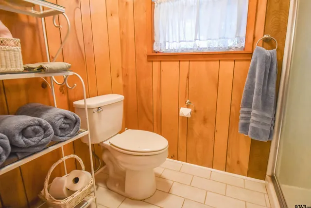 a bathroom with a toilet and a shower curtain