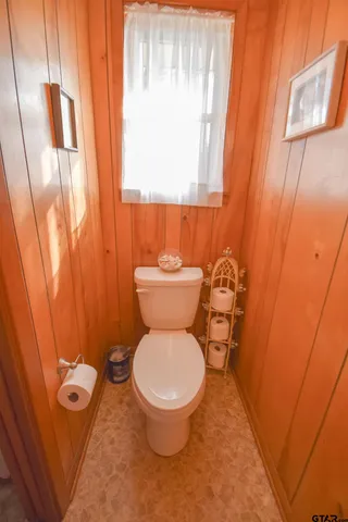 a white toilet sitting next to a small window
