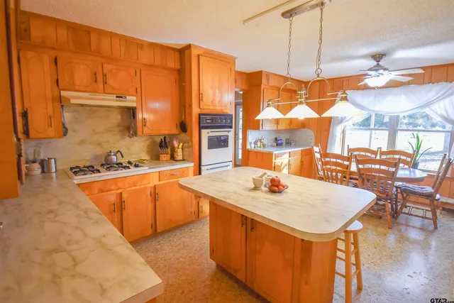 a kitchen with stainless steel appliances granite countertop a sink a stove and a wooden floors