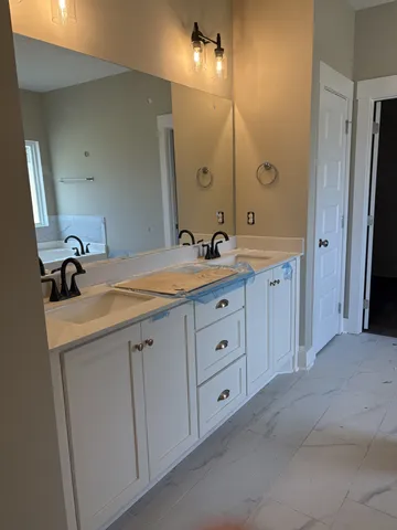 a bathroom with a double vanity sink and mirror with shower
