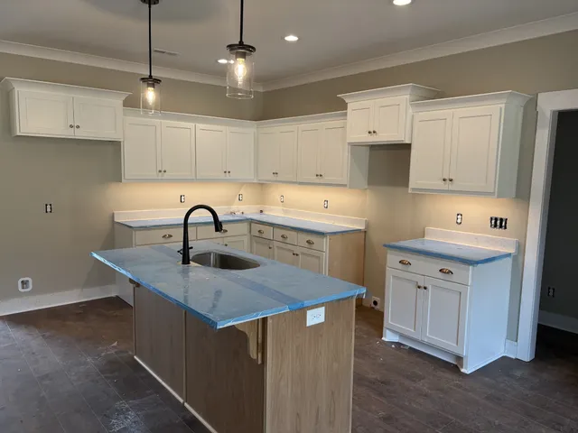 a kitchen with white cabinets appliances and sink