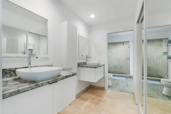 a bathroom with a granite countertop sink and a mirror