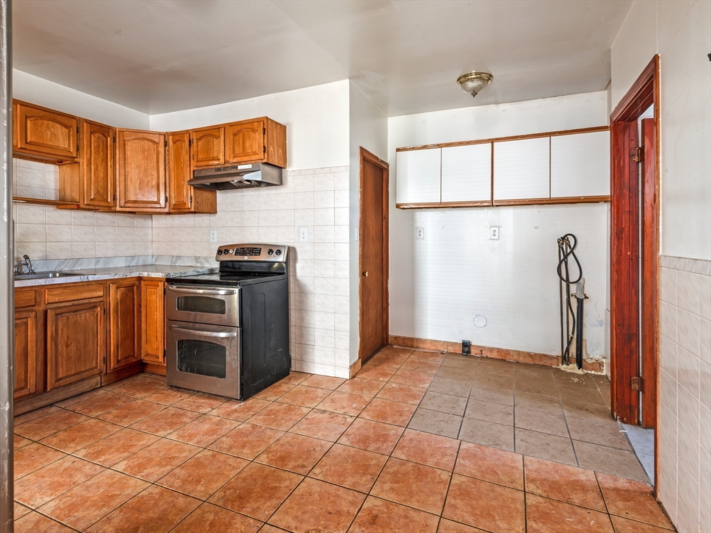 549 Cambridge Street Worcester, MA 01610 - Photo 13 of 22 a kitchen with stainless steel appliances granite countertop a refrigerator and a stove