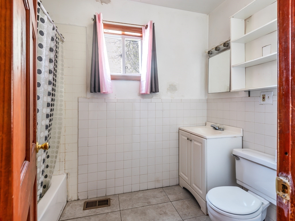 549 Cambridge Street Worcester, MA 01610 - Photo 14 of 22 a bathroom with a toilet and a shower curtain