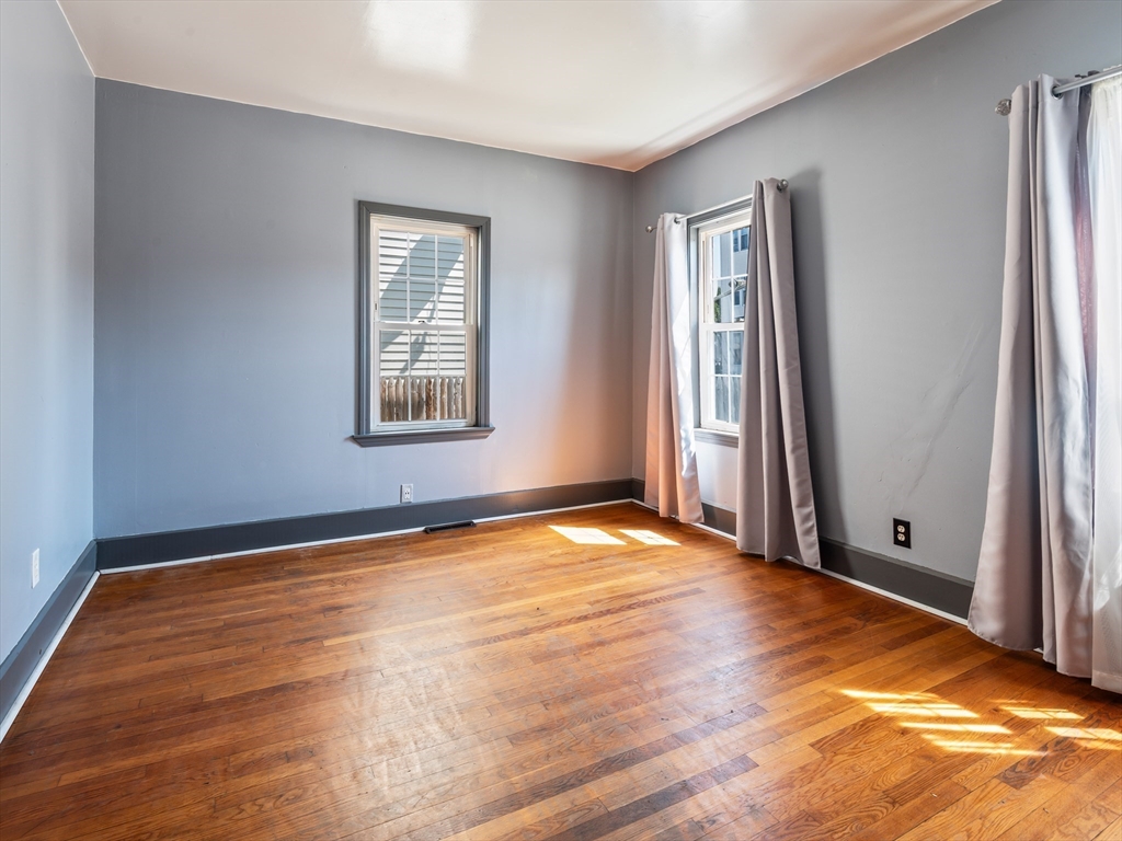 549 Cambridge Street Worcester, MA 01610 - Photo 5 of 22 a view of an empty room with window and wooden floor