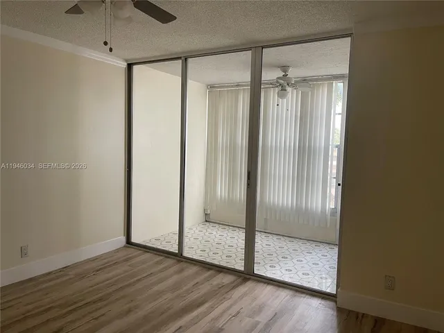 a view of empty room with wooden floor