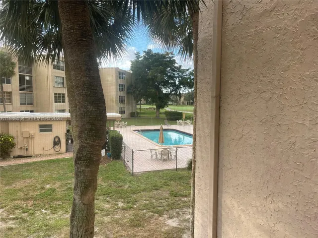 a view of a yard with cars parked on the road