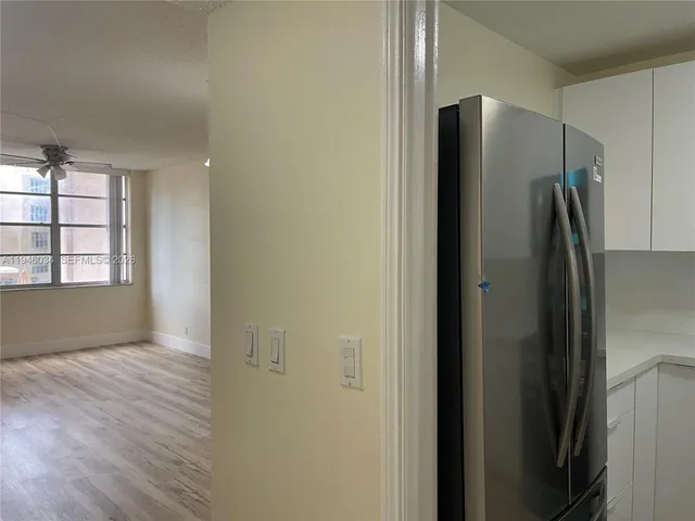 a view of a refrigerator in kitchen and wooden floor