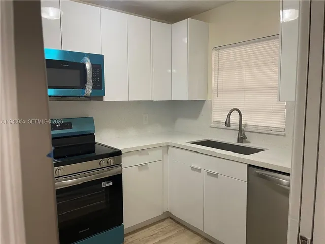 a kitchen with cabinets appliances and a sink