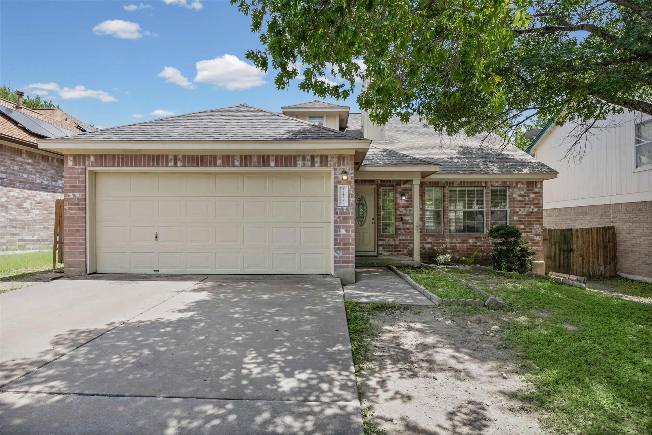 2432 Roundabout Lane Round Rock, TX 78664 - Photo 1 of 22 A brick facade residence presents a two-car garage, welcoming front entry, and mature landscaping.