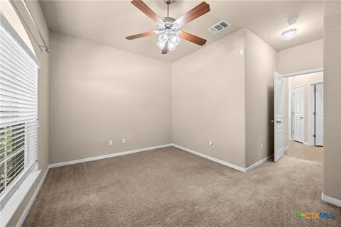 an empty room with closet and a chandelier fan