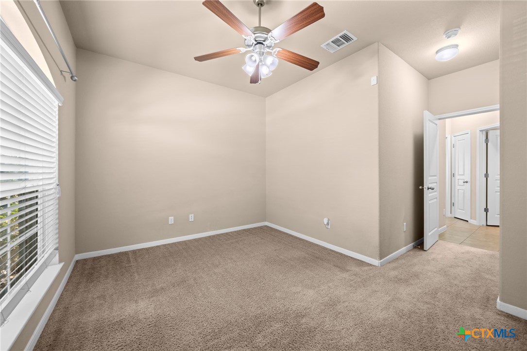 517 Coventry Drive Temple, TX 76502 - Photo 12 of 34 an empty room with closet and a chandelier fan