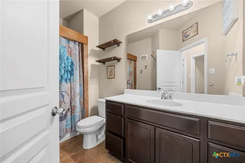 a bathroom with a granite countertop sink toilet a mirror and shower