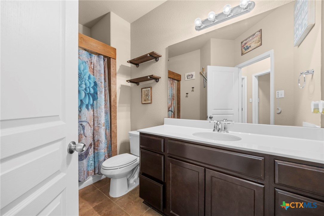 517 Coventry Drive Temple, TX 76502 - Photo 13 of 34 a bathroom with a granite countertop sink toilet a mirror and shower