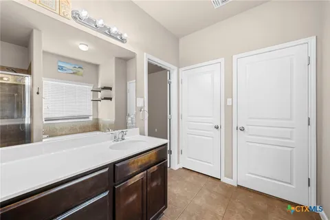 a bathroom with a sink a mirror and a shower