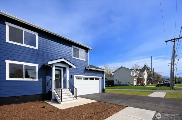 a front view of a house with a yard and a garage