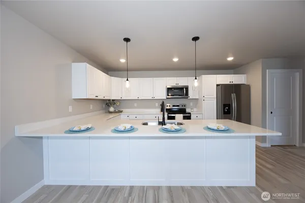 a kitchen with stainless steel appliances granite countertop a sink refrigerator and cabinets