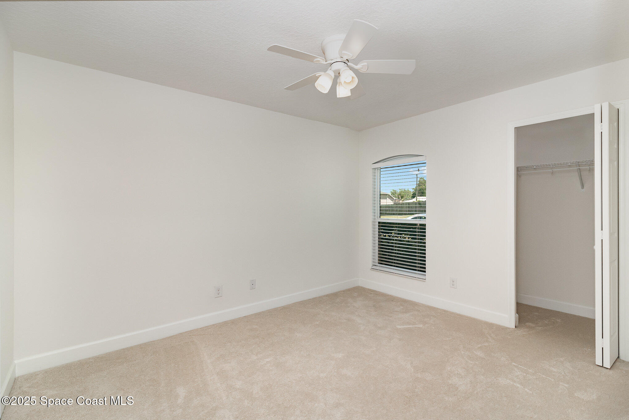 691 Belvedere Road Northwest Palm Bay, FL 32907 - Photo 15 of 26 an empty room with a window and a ceiling fan